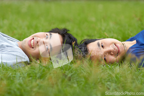 Image of Happy, relax and portrait of a gay couple in the grass for love, bonding and happiness in a park. Smile, lgbtq and Asian men in nature for a date, romance and relaxing together on a lawn or field