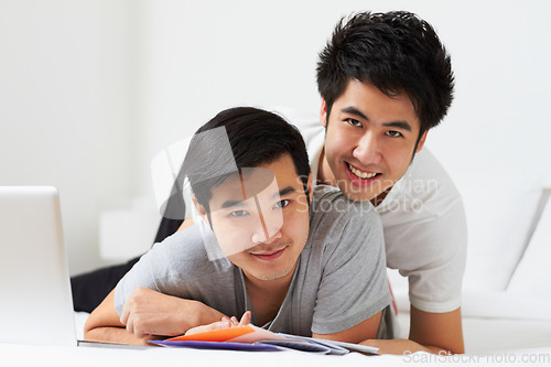 Image of Portrait, lgbt and love with an asian couple learning together in their home while bonding over education. Study, happy or smile with a gay man and partner in a house, studying as university students
