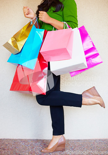 Image of Shopping, legs and bags with a woman customer in studio on a white background for retail consumerism. Fashion, sale and shoes with a female consumer at a mall, store or luxury market as a shopper