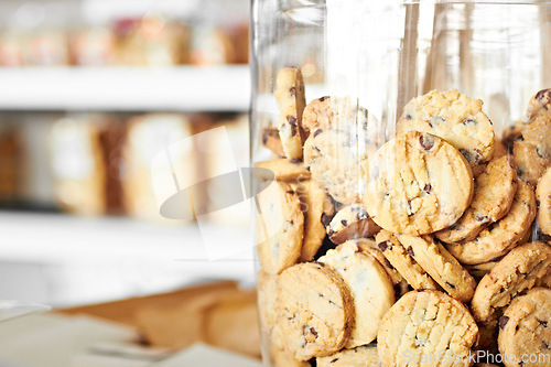 Image of Dessert, bakery and closeup of jar with cookies for coffee shop, sugar and junk food. Cooking, chocolate and nutrition with oatmeal biscuit in container in cafe for snack, breakfast and pastry