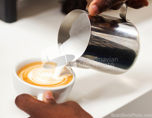 Image of Coffee, closeup hand of a barista and pouring milk in a cup in a cafe in the morning. Latte or cappuccino, cafeteria and hands of a person pour a hot beverage for expresso drink at kitchen counter