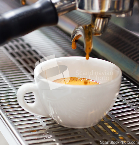 Image of Coffee machine, restaurant and espresso or hot drink in a cup at a small business on counter top. Kitchen, cafe and pouring latte or caffeine at shop with preparation with electrical appliance.