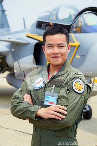 Image of Portrait of man, pilot in military with jet and confident smile at airforce base with arms crossed in Korea. Freedom, transport and proud Asian soldier with airplane, confident and service in army.