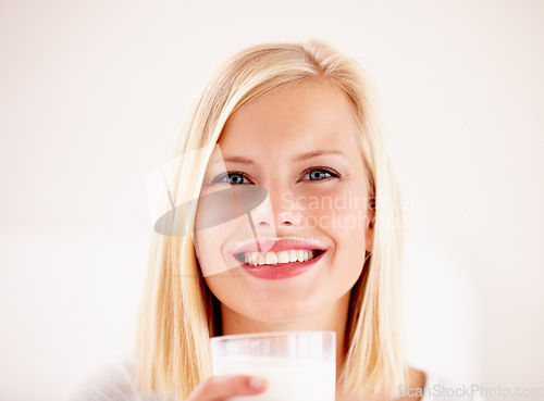 Image of Portrait, milk mustache and a woman drinking from a glass in studio isolated on a white background. Happy, nutrition and calcium with a health young female enjoying a drink for vitamins or minerals
