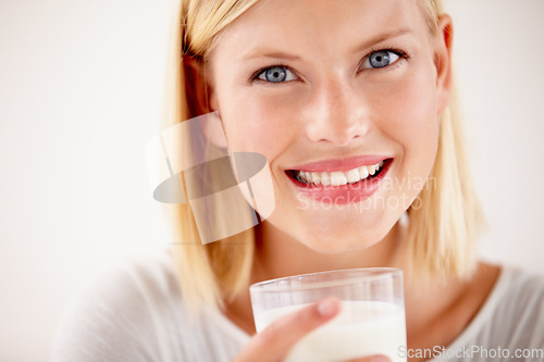 Image of Dairy, woman drinking a glass of milk and in a white background with a smile. Health wellness or natural nutrition, healthy and female person drink with happy face in a studio background smiling