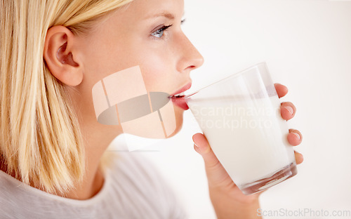 Image of Profile, milk or nutrition with a woman drinking from a glass in studio isolated on a white background. Health, detox and calcium with a young female enjoying a drink for natural vitamins or minerals