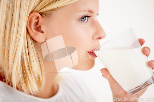 Image of Face, milk and thinking with a woman drinking from a glass in studio isolated on a white background. Idea, nutrition and calcium with a healthy young female enjoying a drink for natural vitamins