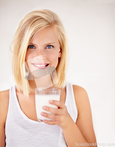 Image of Portrait, milk and health with a woman drinking from a glass in studio isolated on a white background. Healthy, nutrition and calcium with a young female enjoying a drink for vitamins or minerals