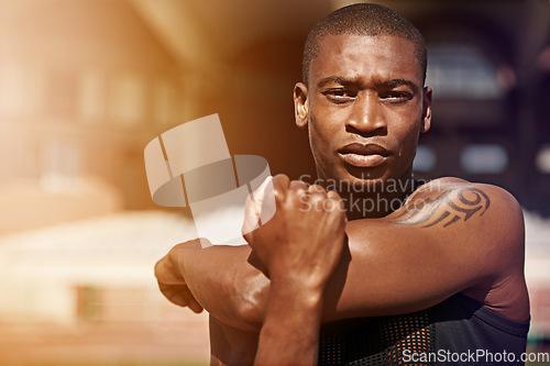 Image of Fitness, portrait and man stretching arms outdoor for running, workout and training on blurred background. Face, stretch and African male runner with serious, focus and mindset, training and warm up