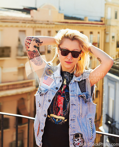 Image of Tattoo, portrait and woman with sunglasses in city, urban body art or stylish fashion outdoor. Face, rooftop or trendy female person from Canada in cool denim clothes, jacket or serious punk attitude