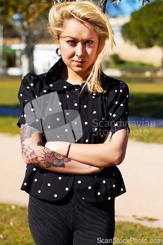 Image of Tattoo, portrait and woman at park with arms crossed for stylish body art outdoor. Punk, confident or edgy young female person from Canada standing in cool clothes, trendy fashion or serious attitude