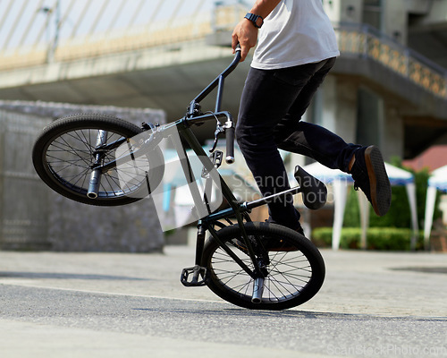 Image of Fitness, cycling tricks and a man with a bicycle for sports, balance and action in the city. Training, energy and a person with a bike for speed, transportation and urban spinning on the concrete