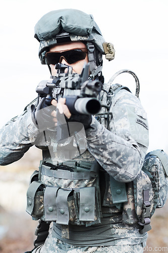 Image of Soldier man, gun and outdoor with aim, field and nature for war, fight and army in countryside. Military service, battlefield and agent with machine weapon, gear and helmet for conflict in Ukraine