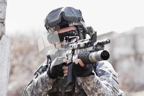 Image of War, training and man with gun in the army for a target, service or a mission. Military, hero and a soldier with a rifle on the battlefield for shooting, danger or violence with a firearm for defense