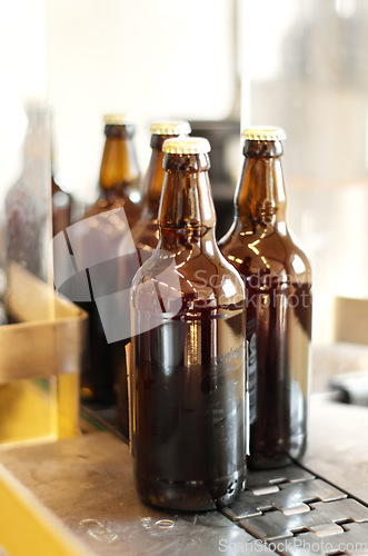 Image of Assembly line, beer and bottles in factory, brewery or manufacturing plant. Alcohol glass, conveyor machine and automation of production in warehouse for industrial process in alcoholic industry.
