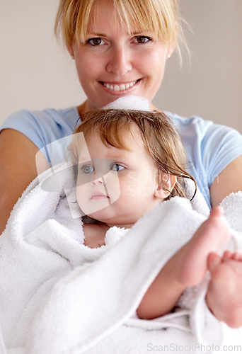 Image of Portrait, mother and baby with happiness in a towel for bath with bond and love in a closeup at house. Child, care and mom with towel for hug for comfort and affection with smile in family home.