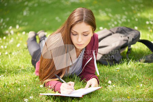 Image of Woman, student and grass for writing, notebook and planning at university, campus and park for studying. Girl, book and pen for education, learning and brainstorming on lawn at college in sunshine