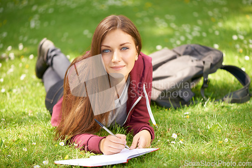 Image of Woman, student and grass for writing, portrait or planning at university, campus or park for studying. Girl, book and pen for education, learning or brainstorming ideas on lawn at college in sunshine