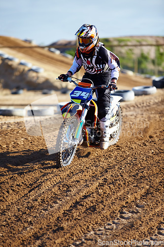 Image of Adventure, offroad and biker riding a motorcycle with speed for a race or sport competition. Sports, fitness and male athlete on motorbike for adrenaline, training or practicing on outdoor dirt trail