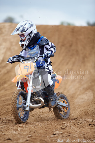 Image of Motorcycle, sports and a child rider on a dirt track for racing, adventure or adrenaline outdoor during a hobby. Fitness, children and freedom with a boy kid on a bike for speed training or challenge