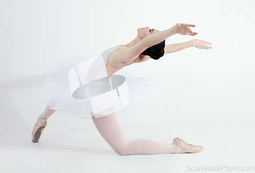 Image of Creative, dance and ballet with a woman in studio on a white background for rehearsal or recital for theatre performance. Art, flexible and music with a young female ballerina or dancer in uniform