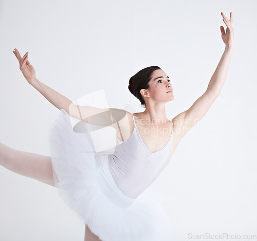 Image of Music, dance and ballet with a woman in studio on a white background for rehearsal or recital for theatre performance. Art, creative and focus with a young female ballerina or dancer in uniform