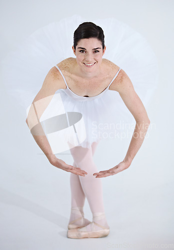 Image of Portrait, dance and ballet with a woman in studio on a white background for rehearsal or recital for theatre performance. Art, creative and smile with a happy young ballerina or dancer in uniform