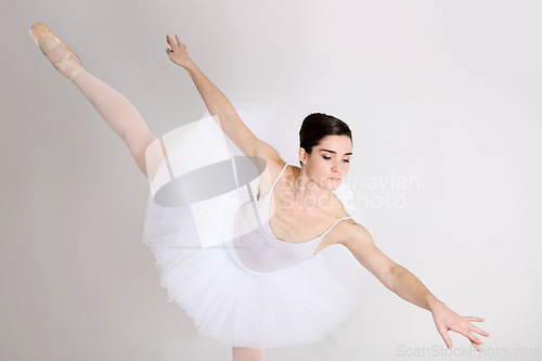 Image of Balance, dance and ballet with a woman in studio on a white background for rehearsal or recital for theatre performance. Art, creative and elegance with a young female ballerina or dancer in uniform