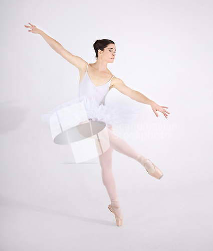 Image of Elegance, dance and ballet with a woman in studio on a white background for rehearsal or recital for theatre performance. Art, creative and balance with a classy young ballerina or dancer in uniform