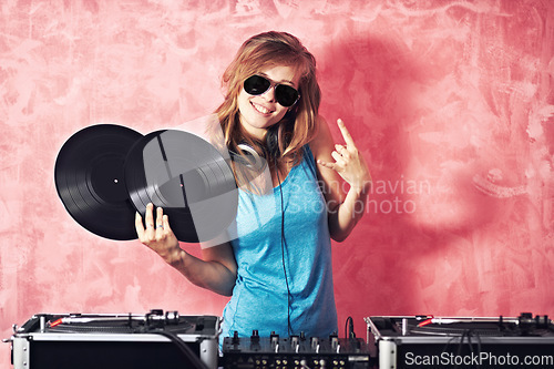 Image of DJ woman, mixer and smile in portrait with vinyl records, sunglasses and horns sign at club, studio or party. Girl, music and party with rock icon, turntable or attitude for event, celebration or job