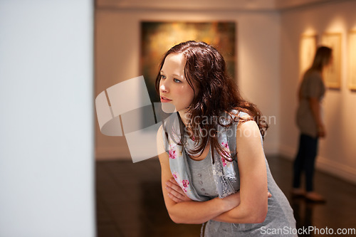 Image of Museum, exhibition and a woman in a painting gallery, looking at photography art in creative appreciation. Artistic, design and culture with an attractive young female at an expo or artwork exhibit
