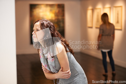 Image of Gallery, woman and studying art at exhibition, museum or creative painting on a wall for a show in artist studio. Study, thinking and girl with focus on abstract paintings, culture or artwork buyer