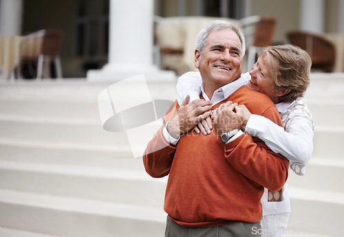 Image of Hug, retirement and an old couple on hotel steps for travel, vacation or tourism in luxury accommodation. Love, relax or hospitality with a senior man and woman hugging on the staircase of a resort
