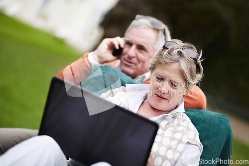 Image of Phone call, laptop and travel with an old couple in a hotel garden for vacation at a luxury resort. Love, technology or communication with a senior man and woman tourist outdoor on grass at a lodge