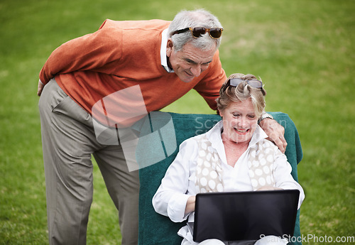 Image of Love, laptop and an old couple in the garden of a hotel for travel or vacation at a luxury resort. Retirement, technology or social media with a senior man and woman tourist on the grass at a lodge