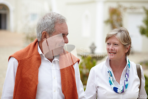 Image of Smile, conversation and a senior couple in the city for a retirement holiday, travel and happiness. Happy, love and an elderly man and woman walking in an old town or hotel during a vacation together