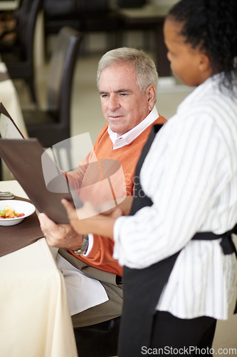 Image of Waitress, hotel and senior man in a restaurant for breakfast or lunch at a hotel with a menu and choice of food. Friendly, order and elderly person happy on vacation or holiday for hospitality