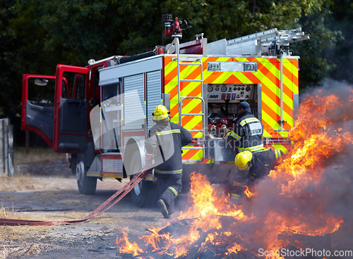 Image of Fire, teamwork and truck with firefighter and emergency in nature for smoke, safety and explosion. Danger, fearless and training with team of men in outdoor for rescue, saving operation and action