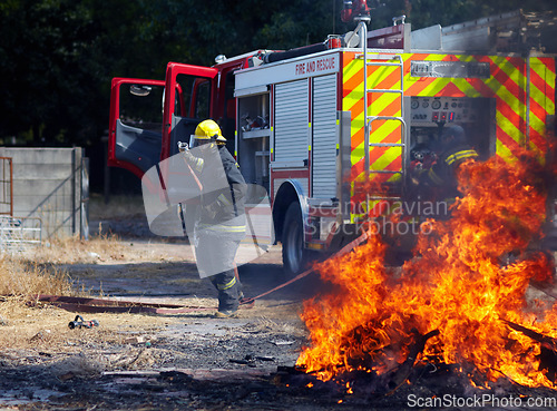 Image of Fire, training and truck with firefighter and emergency in nature for smoke, safety and explosion. Danger, fearless and teamwork with group of men in outdoor for rescue, saving operation and action