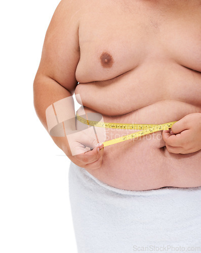 Image of Overweight, tape measure and man checking diet progress and weight loss goal in studio. White background, hands and model with plus size stomach with body problem and health issue with towel