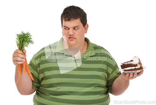 Image of Plus size, diet decision and angry man with a carrot and cake choice thinking about balance. Upset male model, studio and white background with healthy and dessert feeling hungry and frustrated