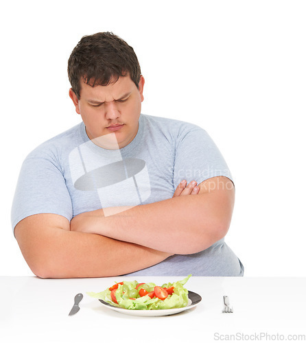 Image of Unhappy, angry and man frustrated by healthy food, meal or salad diet isolated in a studio white background. Obesity, overweight and young man with eating problem and sad for a plate with lettuce