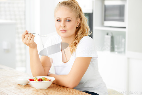 Image of Fruit, thinking and woman eating healthy food or breakfast meal or diet in the morning in her home kitchen. Nutrition, health and vegan person smile and happy for salad, balance and self care