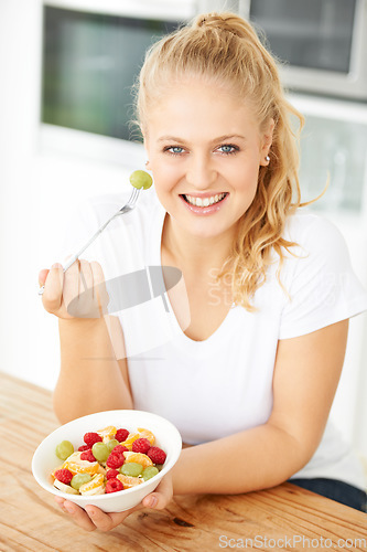 Image of Fruit, bowl and portrait of woman eating healthy lunch or breakfast meal or diet in the morning in her home kitchen. Nutrition, health and vegan person smile and happy for salad, food and self care