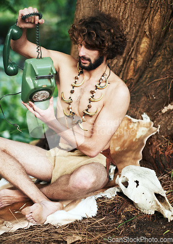 Image of Caveman, forest and modern artifact holding a phone feeling curious outdoor in the woods. Bone necklace, wilderness and first man with technology and communication discovery of a person in nature