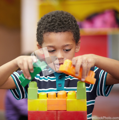 Image of Plastic building blocks, school and boy with education, learning and happiness with safety, relax and kindergarden. Male child, kid and toddler in a classroom, fun and creative student in a creche