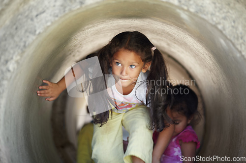 Image of Playground, children and play in tunnel, explore or having fun together. Kindergarten, tube and young girl, kids and friends playing game, adventure or learning, education and enjoying time at school