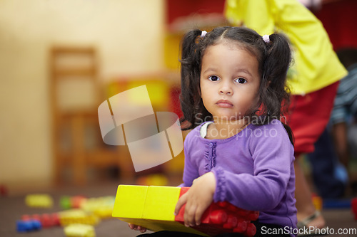 Image of Learning, building blocks and child portrait in school, classroom and education for kindergarten development. Face of girl or kid playing in creche for mind, motor skills and creative games