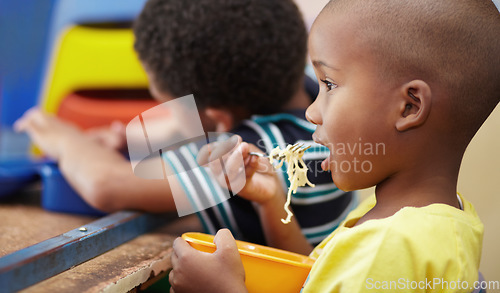 Image of Child, lunch and eating in school, kindergarten or classroom and healthy nutrition, food and noodles. Kids, black boy and hungry kid or eat snack, pasta in lunchbox or breakfast in kindergarden