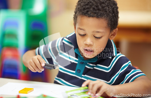 Image of School, creative and a child drawing in a class for education, learning and creativity. Table, classroom and a little male student doing art at kindergarten or creche to learn about color and playing